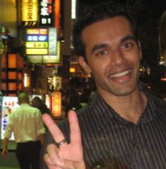 Celso making a peace sign on the night streets of Tokyo.