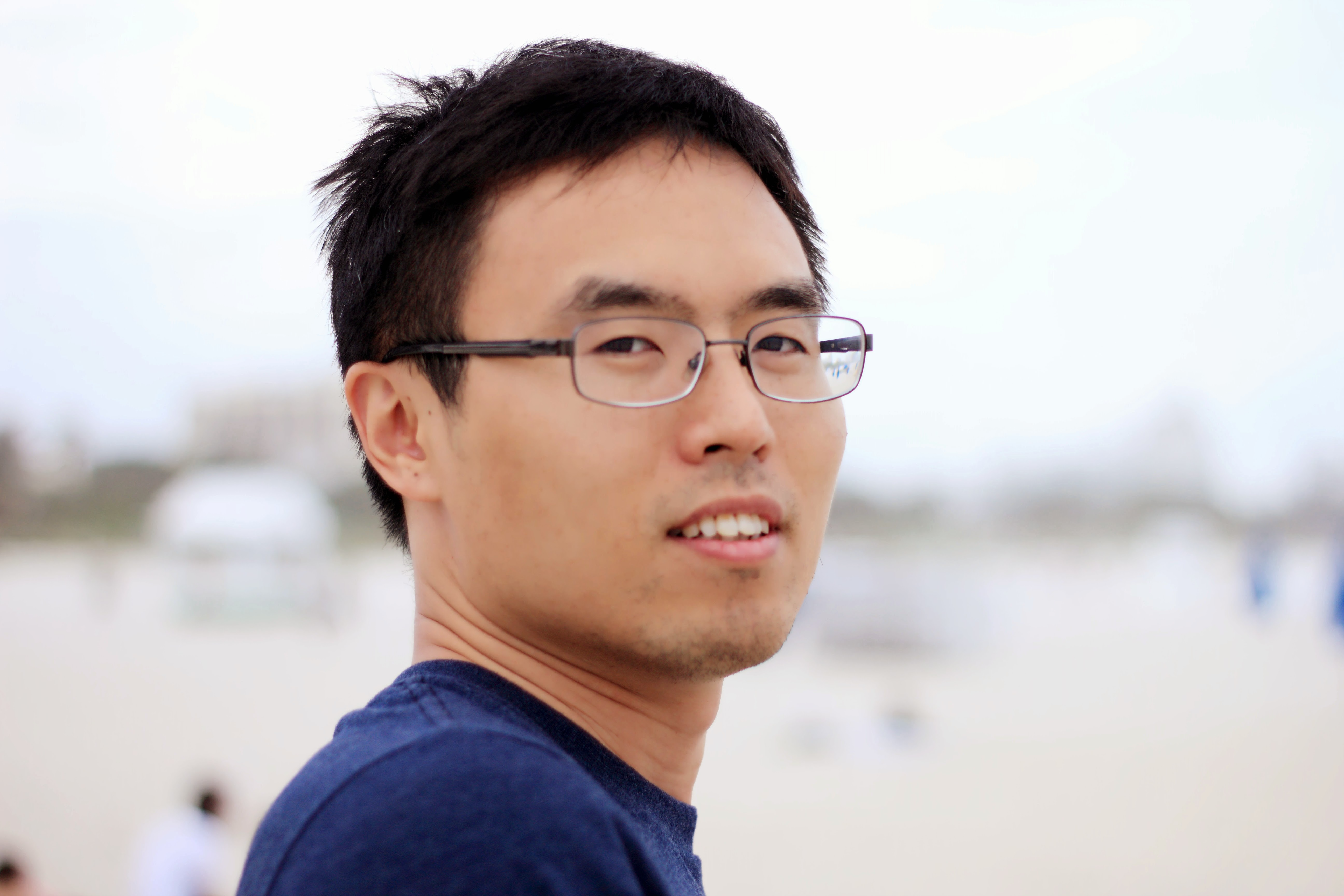 Young Asian man in front of blurred background.